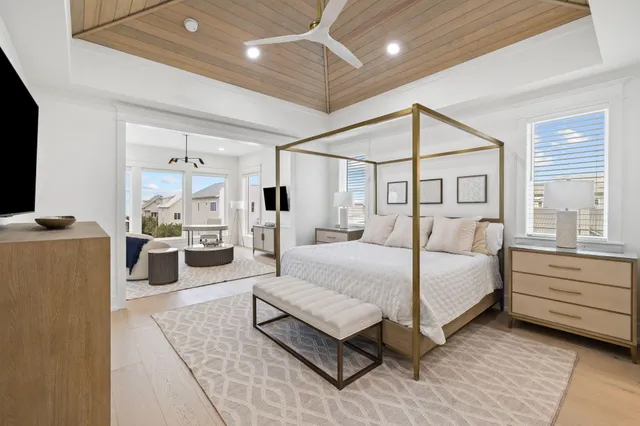 a bedroom with a large bed and a flat tv screen on dresser