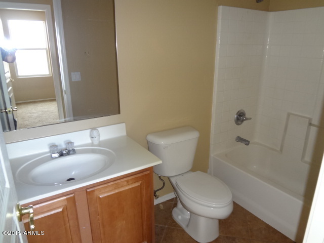 9204 West Payson Road Tolleson, AZ 85353 - Photo 15 of 17 a white toilet sitting next to a bathroom sink