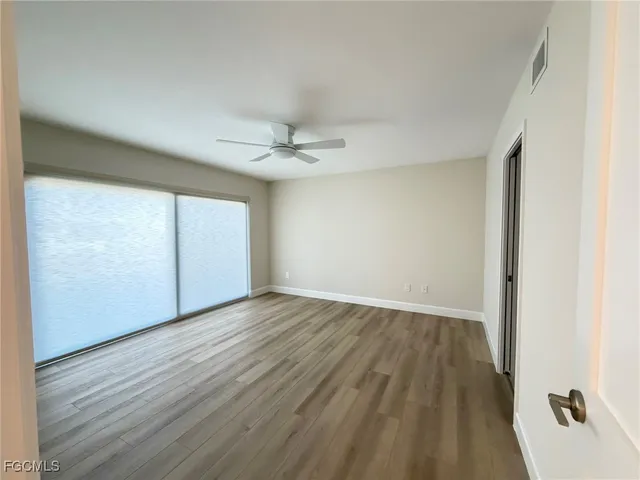 a view of an empty room with wooden floor