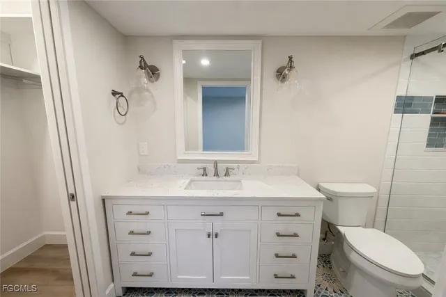 a bathroom with a sink a toilet a mirror and shower