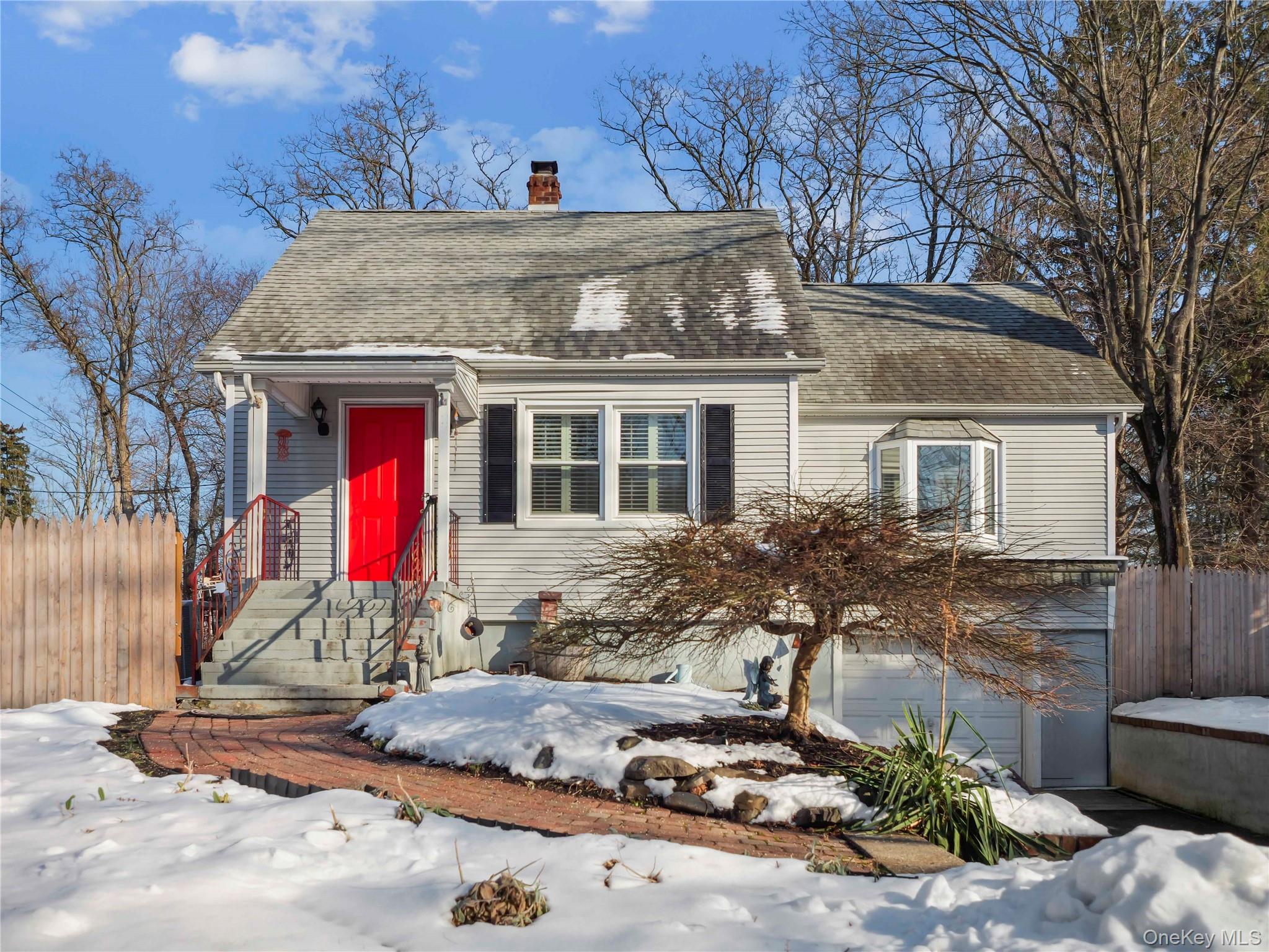 Cape cod house featuring roof with shingles, a chimney, and a garage