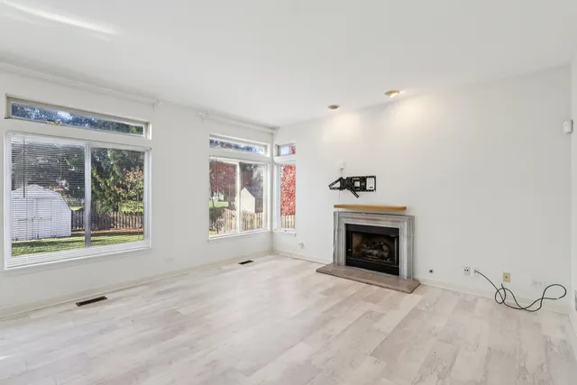 an empty room with fireplace and windows