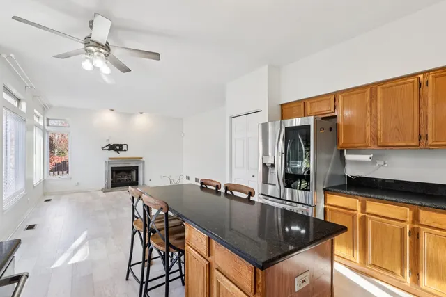 a kitchen with granite countertop a sink chairs and cabinets