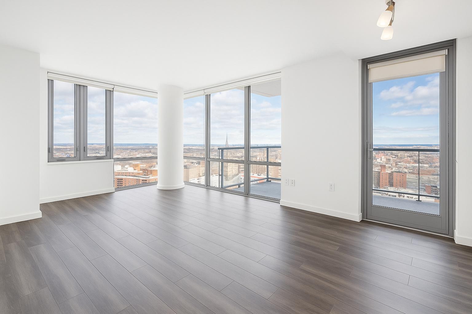 1524 Sheepshead Bay Road, Unit 7G Brooklyn, NY 11235 - Photo 6 of 28 an empty room with wooden floor and windows with curtains