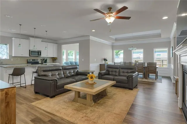 a living room with furniture kitchen view and a chandelier