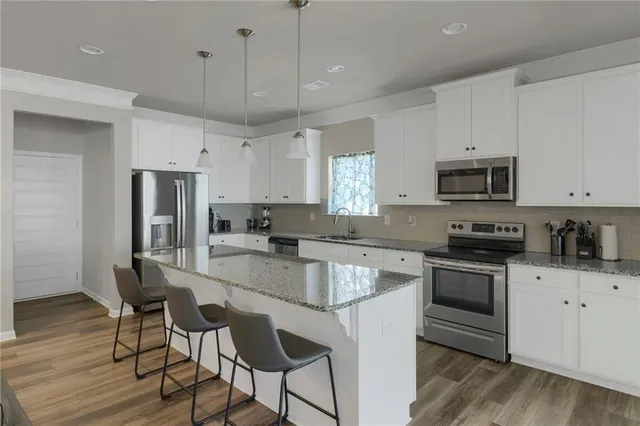 a kitchen with stainless steel appliances granite countertop a stove a sink and a refrigerator