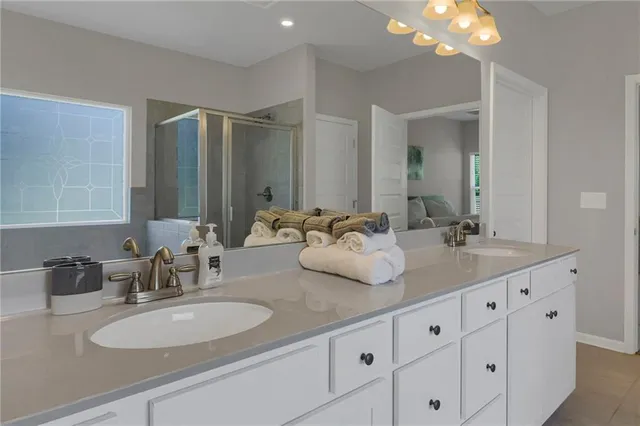 a bathroom with double vanity sinks and a mirror
