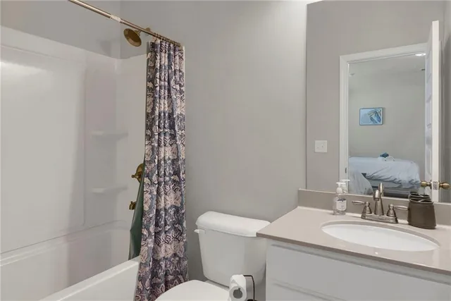 a bathroom with a sink a toilet and shower curtain