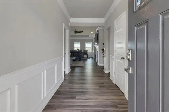 a hallway with wooden floor and staircase