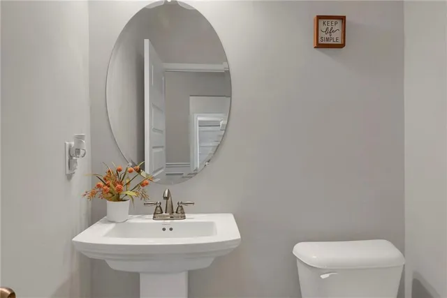 a bathroom with a toilet sink and mirror