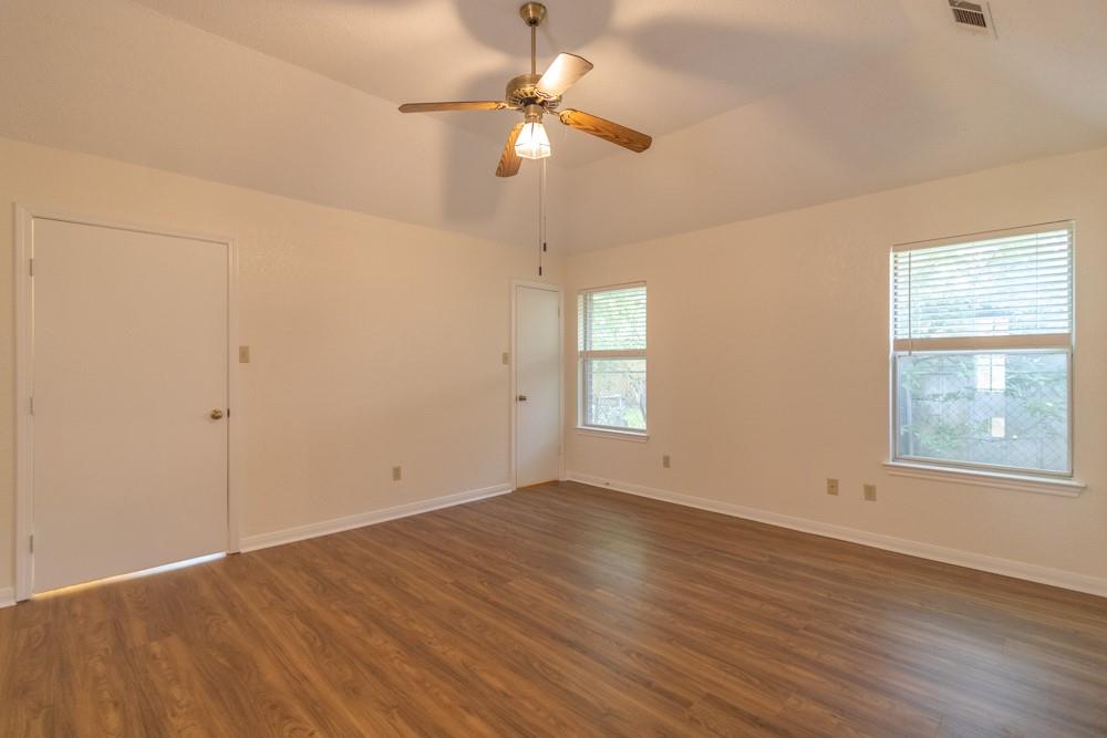 2411 Raintree Path Round Rock, TX 78664 - Photo 17 of 28 an empty room with wooden floor chandelier fan and windows