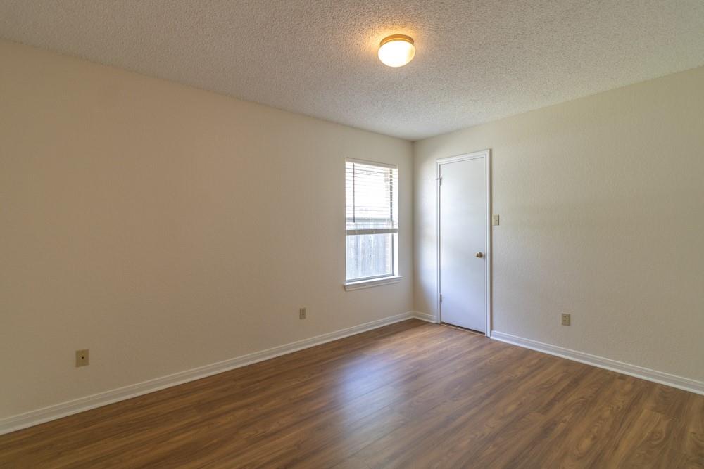2411 Raintree Path Round Rock, TX 78664 - Photo 22 of 28 an empty room with wooden floor and windows