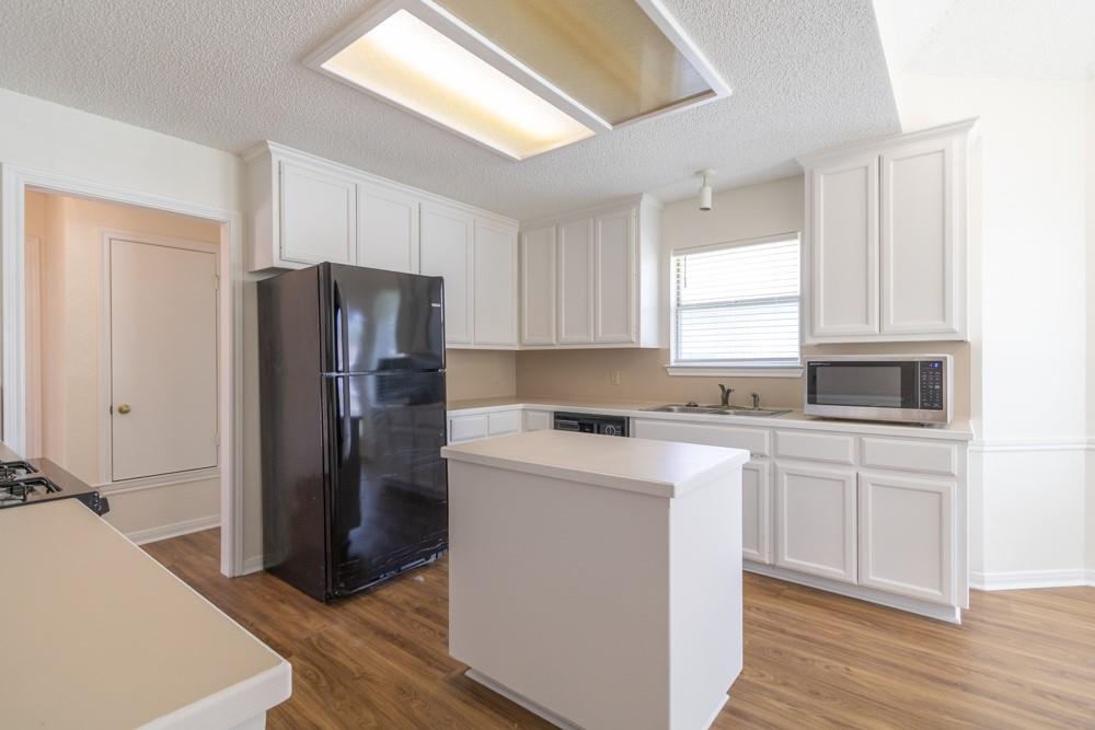 2411 Raintree Path Round Rock, TX 78664 - Photo 3 of 28 a kitchen with a refrigerator sink and cabinets