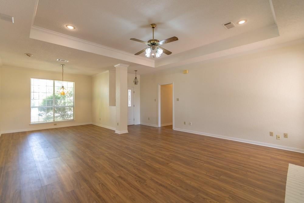 2411 Raintree Path Round Rock, TX 78664 - Photo 8 of 28 an empty room with wooden floor chandelier fan and windows