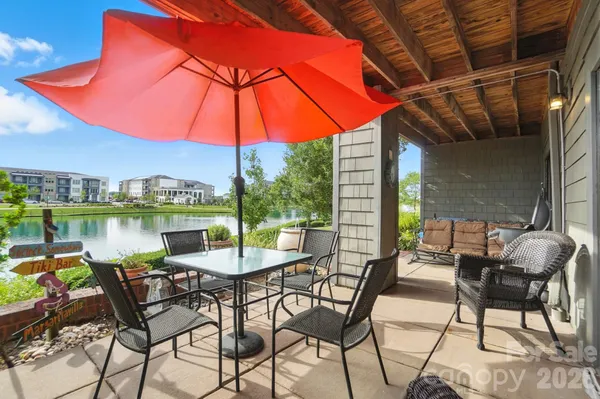 a patio with a table and chairs under an umbrella
