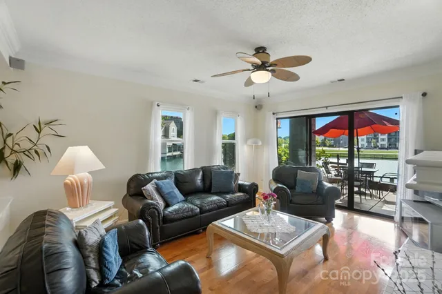 a living room with furniture a ceiling fan and a large window