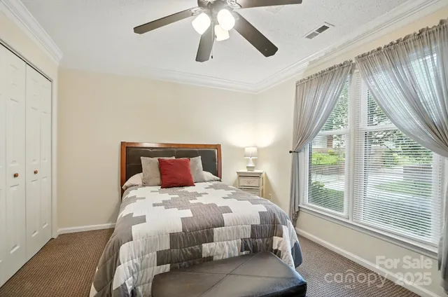 a bedroom with a bed and large windows