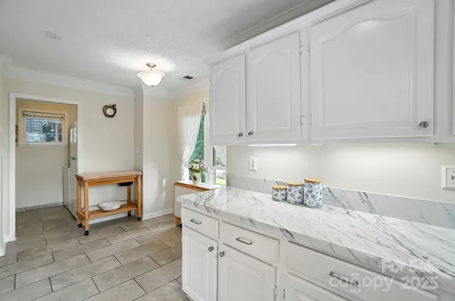a kitchen with granite countertop white cabinets and white appliances