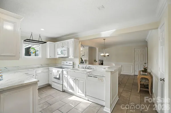 a large white kitchen with a sink and cabinets