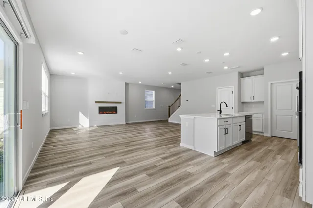 a view of a kitchen with kitchen island white cabinets and wooden floor