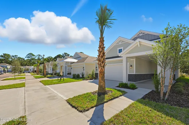 a front view of a house with a yard and trees