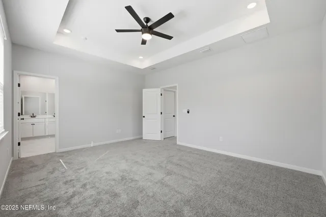 an empty room with a ceiling fan and bathroom