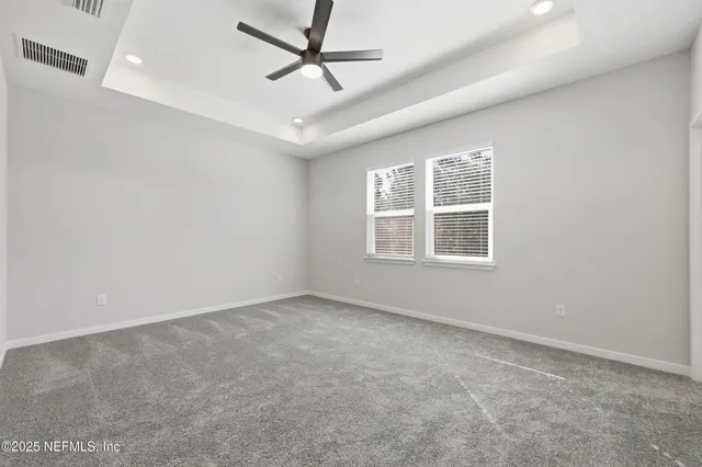 an empty room with a window and ceiling fan