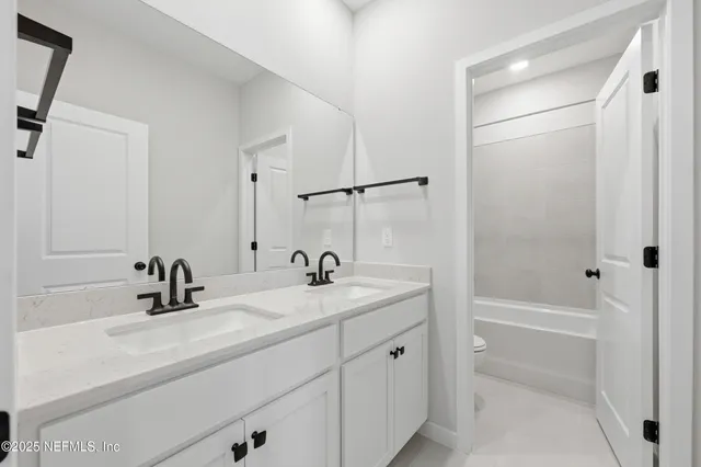a bathroom with a sink tub vanity and a mirror