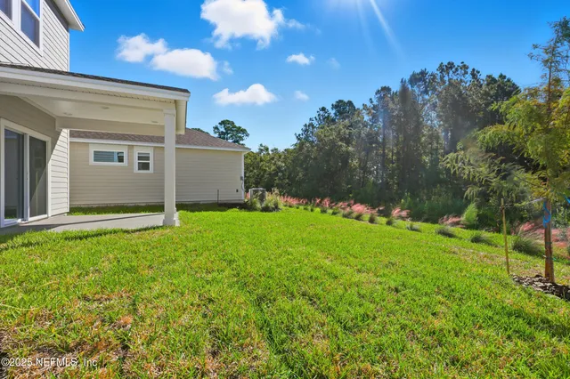 a view of backyard of house with green space