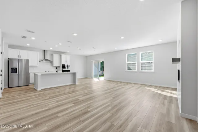 a view of kitchen with refrigerator microwave and wooden floor