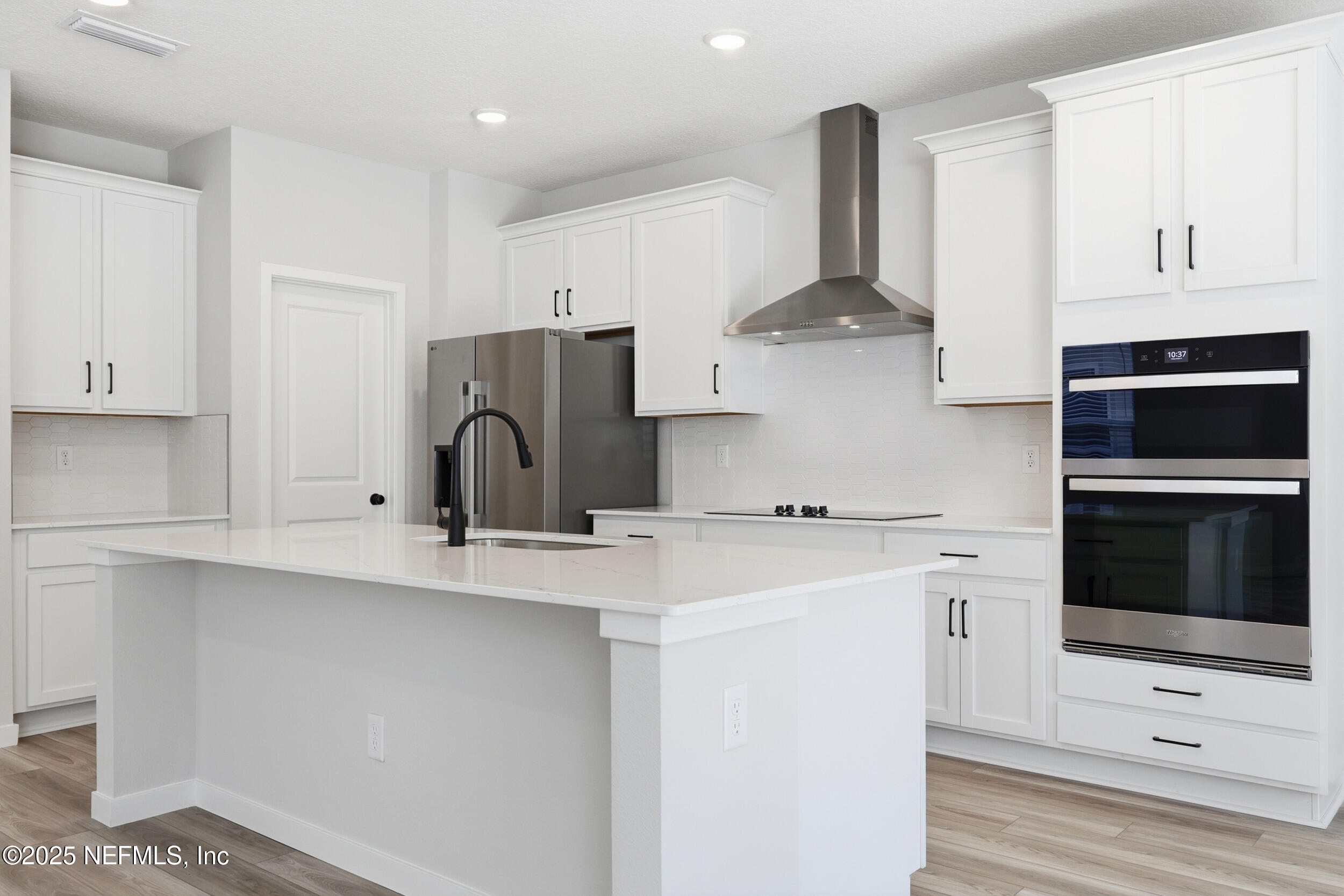 96509 Stillpoint Way Fernandina Beach, FL 32034 - Photo 6 of 32 a kitchen with stainless steel appliances a stove and white cabinets