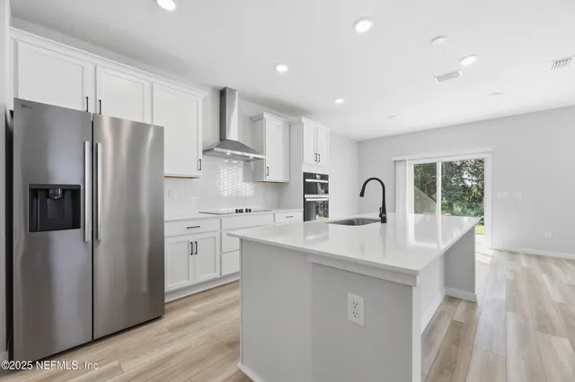 a kitchen with stainless steel appliances a refrigerator sink and cabinets