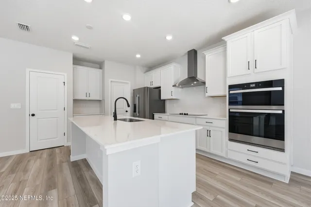 a kitchen with stainless steel appliances a sink stove and cabinets