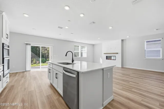 a kitchen with stainless steel appliances granite countertop a stove and a wooden floors