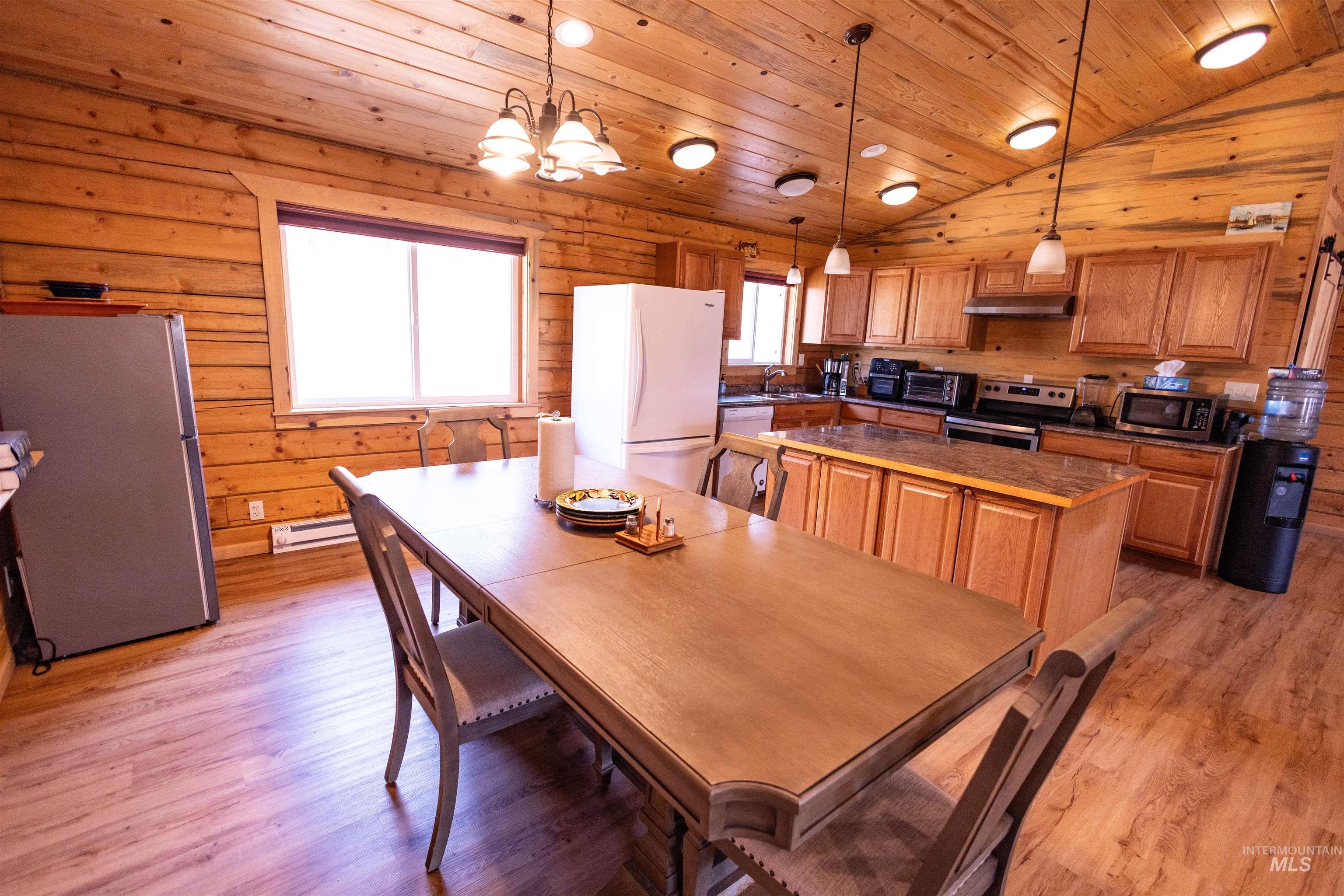 830 Leitch Creek Road Kooskia, ID 83539 - Photo 14 of 49 Dining space with wooden ceiling, vaulted ceiling, light wood-type flooring, wooden walls, and baseboard heating