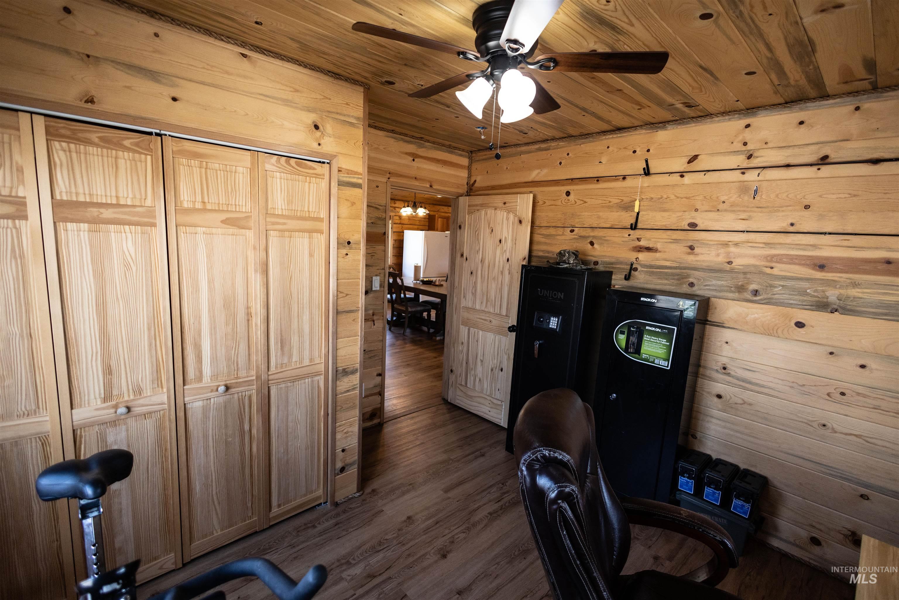 830 Leitch Creek Road Kooskia, ID 83539 - Photo 21 of 49 Home office featuring wood walls, wooden ceiling, dark wood-type flooring, and a ceiling fan