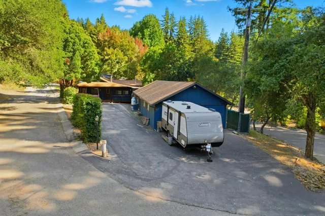 a aerial view of a house with yard and trees