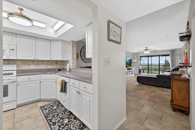 a living room with furniture a flat screen tv and a floor to ceiling window