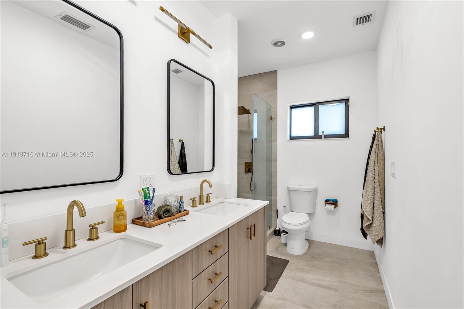 6376 Southwest 15th Street, Unit 6376 West Miami, FL 33155 - Photo 13 of 23 a bathroom with a double vanity sink toilet and mirror