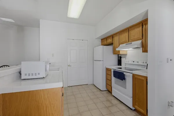 a kitchen with stainless steel appliances granite countertop a sink and a refrigerator