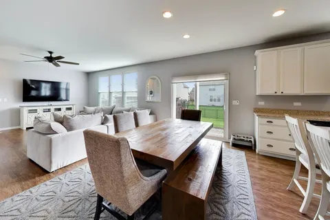 a living room with furniture two windows and a flat screen tv