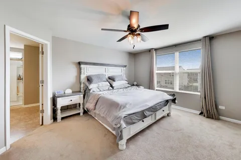 a bed sitting in a spacious bedroom next to a window