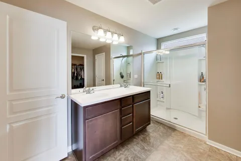 a bathroom with a sink mirror and a shower