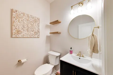 a bathroom with a sink mirror and toilet