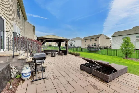 a backyard of a house with table and chairs