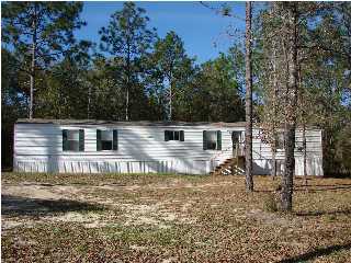 6238 Old River Road Baker, FL 32531 - Photo 1 of 8 a front view of a house with a yard