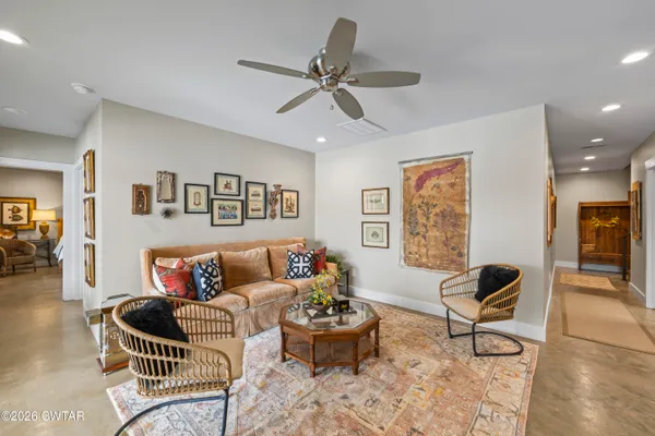 a living room with furniture and floor to ceiling windows