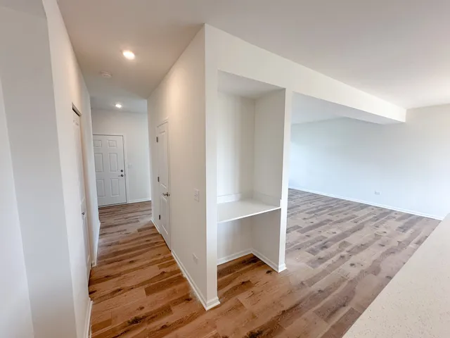 a view of a hallway with wooden floor and entryway