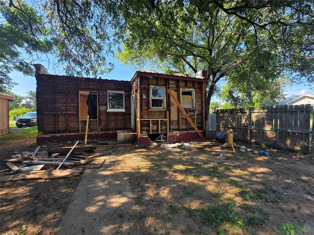 a view of a house with backyard and trees