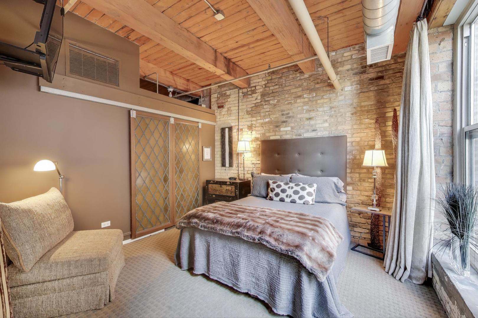 420 South Clinton Street, Unit 414A Chicago, IL 60607 - Photo 8 of 13 a bedroom with a bed and a mirror